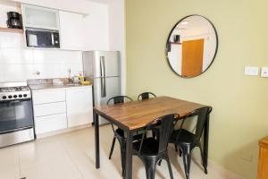 kuchnia ze stołem, krzesłami i lustrem w obiekcie Inmejorable! Piso alto en Centro BsAs, Moderno con parrilla y pileta 3 pax w BuenosAires