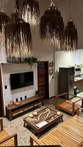 卡莫辛的住宿－Vila Cangalha，客厅配有桌子、电视和吊灯。