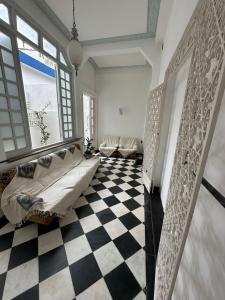 a living room with a bed and a checkered floor at Casa de Maria Marta in Ilhéus