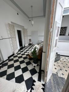 uma sala de estar com um piso em xadrez e um quarto com um quarto em Casa de Maria Marta em Ilhéus