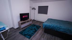 a bedroom with a bed and a flat screen tv at Sky Rooms Modern Luxury 2 Bed Apartment in Birmingham