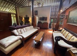 Sala de estar con 2 sofás y mesa en The Joglo Villa, en Bandung