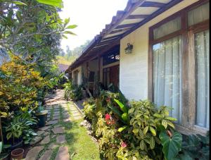 una casa con plantas delante de ella en The Joglo Villa, en Bandung
