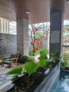 a lobby with a pool and plants in a building at Animor Green Home Villa Da Nang in Da Nang