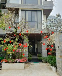 a house with red flowers in front of it at Animor Green Home Villa Da Nang in Da Nang
