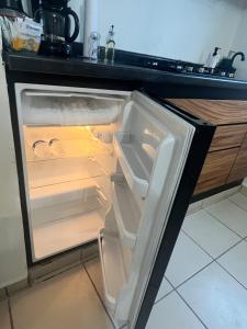 an empty refrigerator with its door open in a kitchen at Departamentos Yahelik in Cabo San Lucas