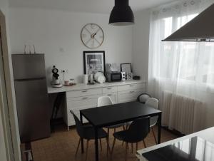 a kitchen with a table and a clock on the wall at Maison T3 près de Toulouse in Frouzins