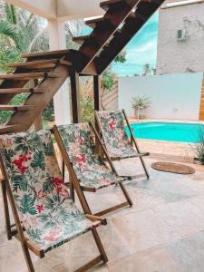 2 sillas sentadas en un patio junto a una piscina en Villa Fortal Preá en Prea