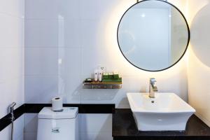 un bagno bianco con lavandino e specchio di Ratana Angkor Hotel a Siem Reap