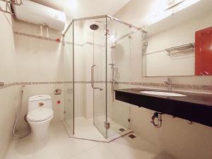 uma casa de banho com um chuveiro, um WC e um lavatório. em Tài Tâm - Spring Suites em Hanói