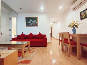 uma sala de estar com um sofá vermelho e uma mesa em Tài Tâm - Spring Suites em Hanói