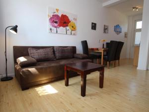 uma sala de estar com um sofá de couro e uma mesa em Terraced house with WiFi em Buchholz