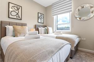 1 dormitorio con 2 camas y ventana en Chic Retreat Residences: 3 BD Haven - Sleeps 10 en Londres