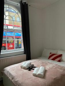 a bedroom with a bed with two towels and a window at Private Bedrooms in Camden Town, Central London (10) in London