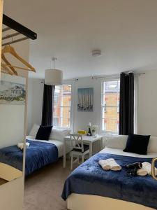 a bedroom with two beds and a table and a desk at Private Bedrooms in Camden Town, Central London (10) in London