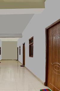 une pièce vide avec une porte et des murs blancs dans l'établissement OYO Flagship Mamta Hotel, à Hājīpur