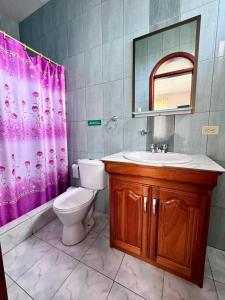 a bathroom with a toilet and a sink and a mirror at GRAND SUN'S HOUSE in Puerto Baquerizo Moreno