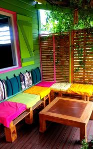 ein Zimmer mit zwei Bänken auf der Veranda eines Hauses in der Unterkunft Le Ti Citron Vert in Saint-Leu