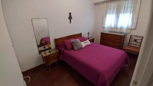 a bedroom with a purple bed and a mirror at Departamento Plaza Colon in Mar del Plata