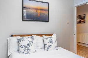 a bed with white pillows and a picture on the wall at Folkestone Ramblers Rest in Kent