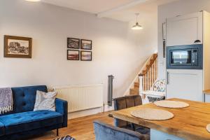 a living room with a table and a blue couch at Folkestone Ramblers Rest in Kent