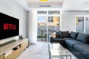 - un salon avec un canapé et une télévision dans l'établissement Adorable Bright Villa in Residential Community, à Dubaï