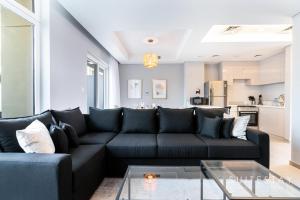 sala de estar con sofá negro y mesa en Adorable Bright Villa in Residential Community, en Dubái