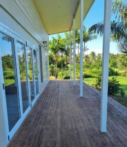 an empty porch of a house with glass doors at Luxury Beachside Home in Maninoa
