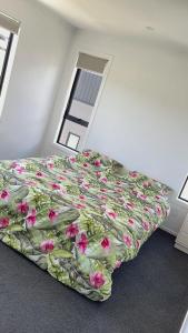 Un dormitorio con una cama con flores. en Nature Haven, City Close, en Upper Hutt