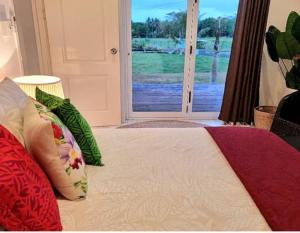 1 dormitorio con cama con almohadas y ventana en Luxury Beachside Home en Maninoa