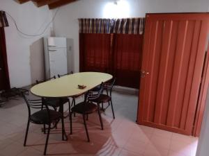 cocina con mesa, sillas y nevera en Los nidos 2 en Villa Cura Brochero