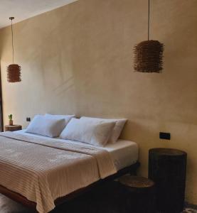 a bedroom with a bed with white sheets and pillows at Sisal Loft Living in Valladolid