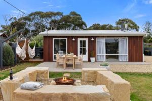 a home with a fire pit in the yard at Salty Air Cottage in Bream Creek