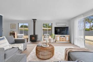 a living room with a couch and a fireplace at Salty Air Cottage in Bream Creek