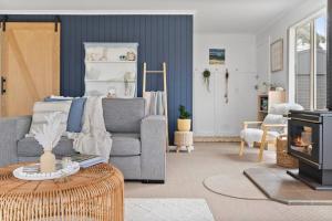 a living room with a couch and a fireplace at Salty Air Cottage in Bream Creek +22 photos