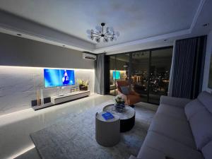 a living room with a couch and a tv at SKY 31 Luxurious Condominium in Phnom Penh