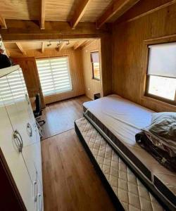 1 dormitorio con 1 cama grande en una habitación en Hermosa cabaña en Valdivia en Valdivia