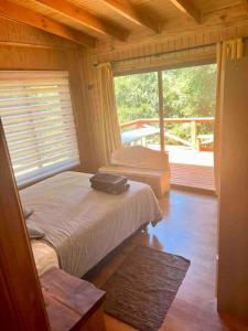 1 dormitorio con cama y ventana grande en Hermosa cabaña en Valdivia en Valdivia
