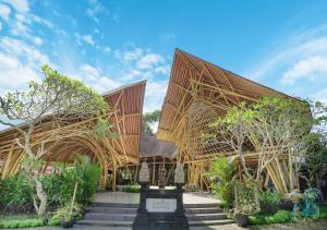 a building with a wooden roof with trees and stairs at Royal Casa Ganesha in Ubud