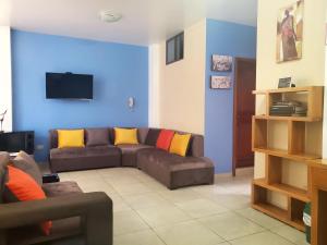 a living room with a brown couch and a blue wall at In the heart of Vilcabamba. Residence don Tuquito. in Vilcabamba