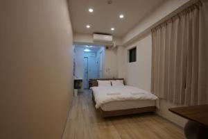 a bedroom with a white bed and a window at Tokyo Guest 浜町 in Tokyo