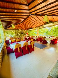 een restaurant met rode en gele stoelen en tafels bij River View Banquet & Resort in Wadduwa