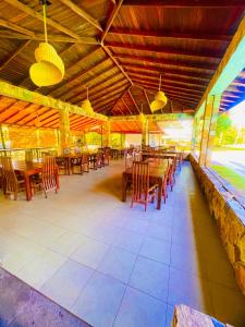 a restaurant with wooden tables and chairs and lights at River View Banquet & Resort in Wadduwa