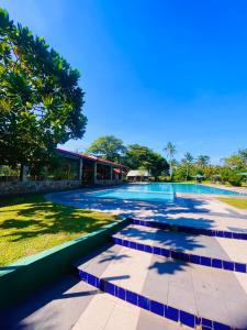 a large swimming pool in a yard with trees at River View Banquet & Resort in Wadduwa