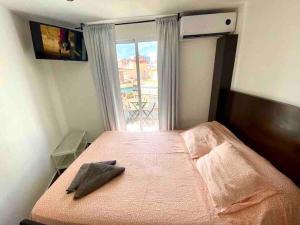 una camera da letto con un letto e una grande finestra di Apartamentos con baño privado frente al metro L5 Barcelona-Hospitalet a Hospitalet de Llobregat