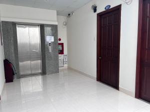 a hallway with a brown door and a tile floor at Residence Á CHÂU in Vung Tau