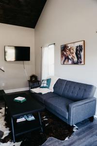 uma sala de estar com um sofá e uma mesa em Creed's Cottage at Four Oaks em New Braunfels