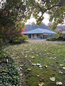 a yard with leaves on the grass in front of a building at Brookfield Guest House in Myrrhee