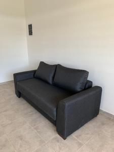 a black couch sitting against a white wall at Housing center in Jesús María