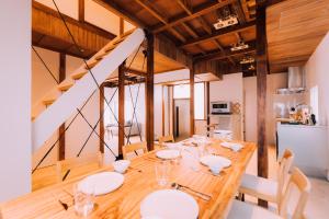 uma sala de jantar com uma mesa de madeira com placas brancas em One Harajuku: Private Oasis em Tóquio
